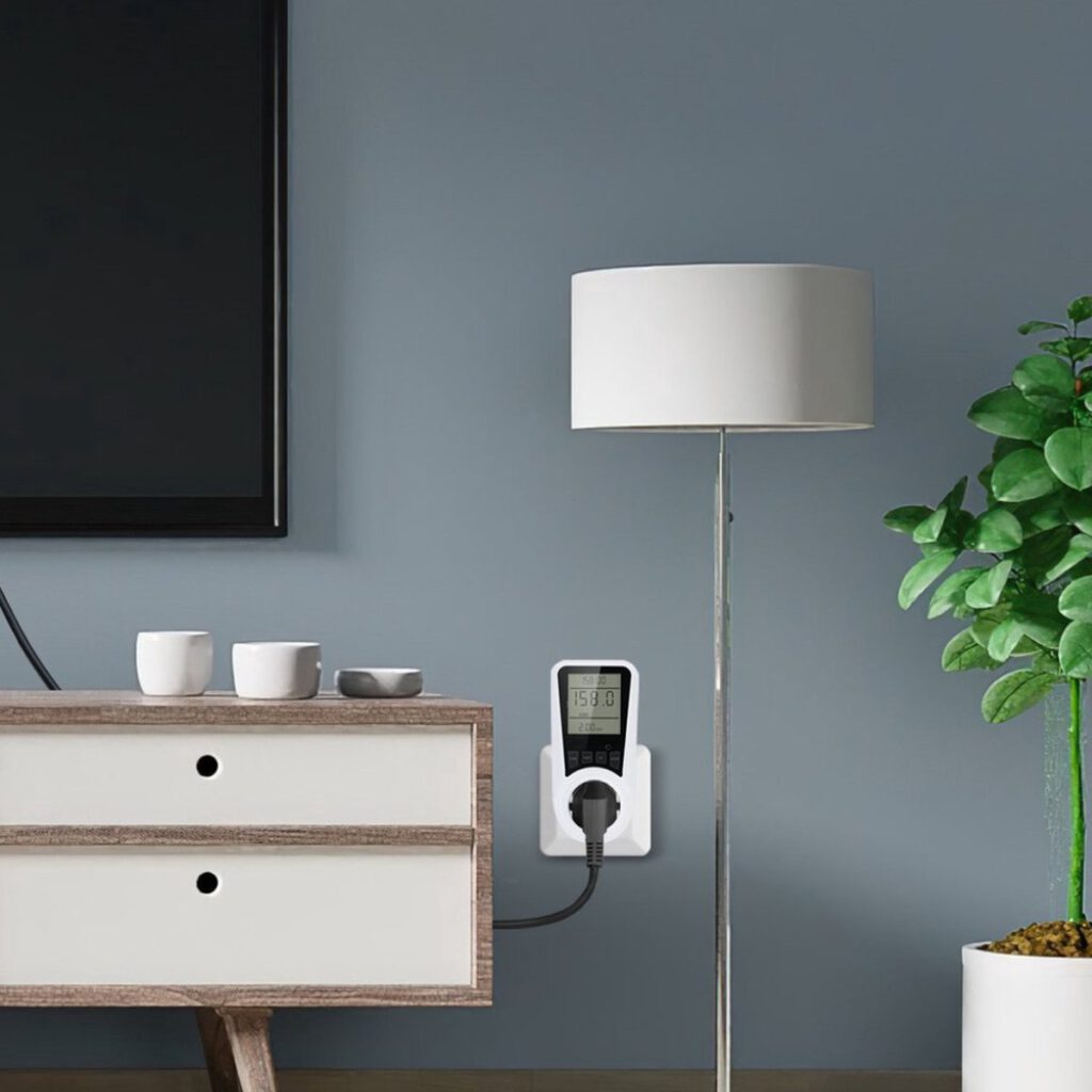 Een witte lamp een tv meubel plant en een energiemeter tegen een grijze muur