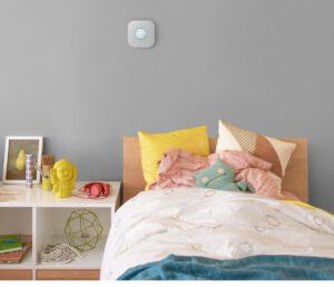 Een kinderbed en nachtkastje met een Google Nest Protect rookmelder