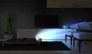 Een donkere woonkamer met een tvsimulator die licht uitstraalt